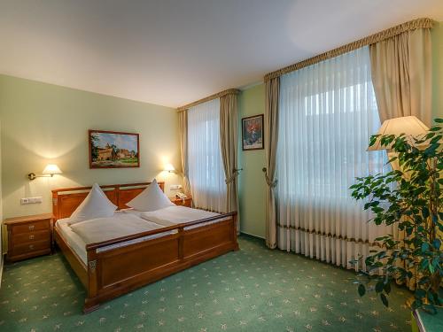 a hotel room with a bed and a large window at Hotel Zur Burg GmbH in Burg Stargard
