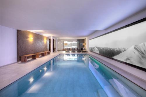 a swimming pool in a building with a large window at Dependance Villa Calluna in Campo Tures