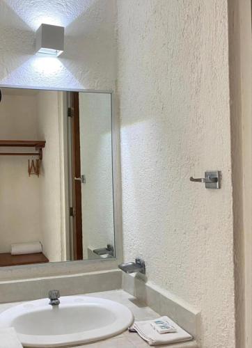 a bathroom with a sink and a mirror at AM Amakal Hotel & Park in Santa Cruz Huatulco