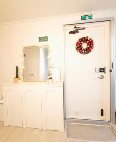 a white door with a christmas wreath and a mirror at 화곡SongStay 무료짐보관 화곡역 도보5분 더현대서울 여의도 in Seoul