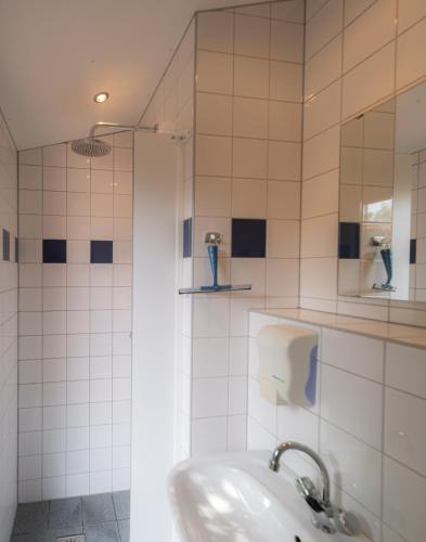 a white bathroom with a sink and a shower at Glampingtent Camping Namasté in Berlicum
