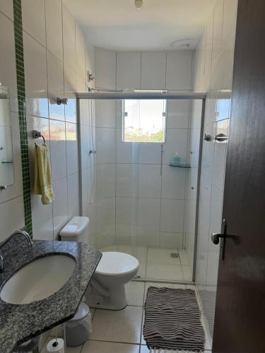 a bathroom with a sink and a toilet and a shower at Apartamento com varanda in Lavras