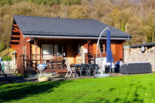 a log cabin with a table and chairs in a yard at Le Mont Céleste dogs friendly in Nonceveux