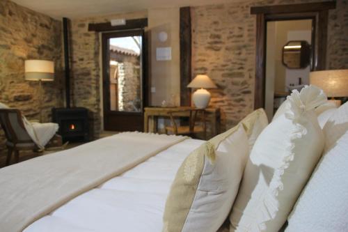 a large bed with white sheets and pillows in a room at HOTEL RURAL SANTUI in Horcajuelo de la Sierra