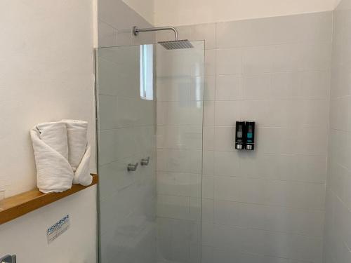 a shower with a glass door in a bathroom at Studios Downtown Cancun in Cancún