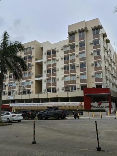 a large building with cars parked in front of it at Miranda's Suite by Fullerton in Silang