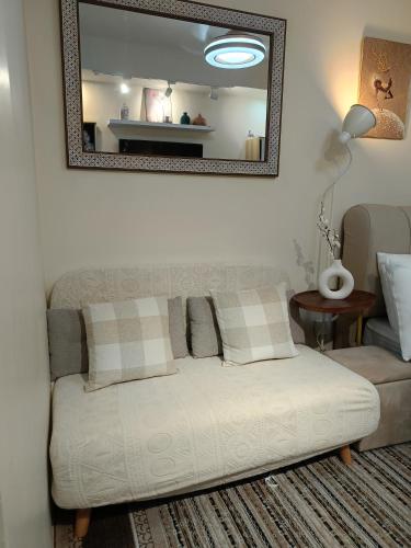 a white couch in a living room with a mirror at Miranda's Suite by Fullerton in Silang