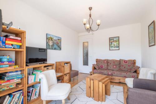 un salon avec un canapé et une télévision dans l'établissement IMPERIAL - Appartement confortable près du lac, à Annecy