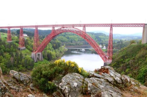 a large red bridge over a river with a bridge at Le Relais de Garabit in Anglards-de-Saint-Flour