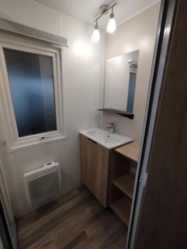 une salle de bain avec un lavabo et une fenêtre dans l'établissement Entre mer et montagne, à Canet
