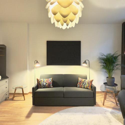 a living room with a couch and a chandelier at Feinzeit Lovely Lou - renovierter Altbau, Design, Zentrum! in Bamberg