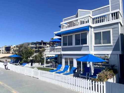 a house with blue chairs and umbrellas at 90210 Beach House Middle Unit in Hermosa Beach