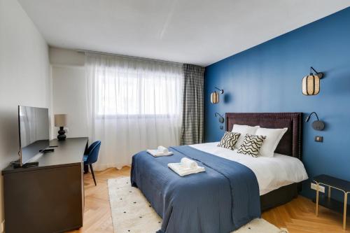 - une chambre avec des murs bleus, un lit et un bureau dans l'établissement 217 Suite Trocadero - Superbe Appartement à Paris, à Paris