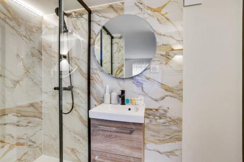 une salle de bain avec un lavabo et un miroir dans l'établissement 217 Suite Trocadero - Superbe Appartement à Paris, à Paris