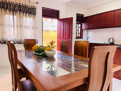 a kitchen with a wooden table with a bowl of fruit at Su Yu villa in Unawatuna
