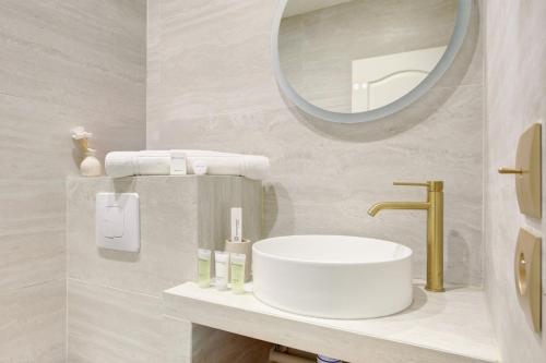 une salle de bain avec un lavabo et un miroir dans l'établissement 201 Suite Anne - Superbe appartement, à Puteaux