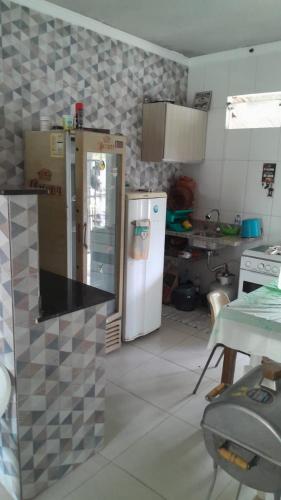 a kitchen with a refrigerator and a table in it at Casa no Guaibim in Valença
