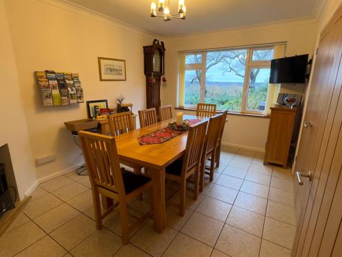 a dining room with a wooden table and chairs at Birchcroft Hideaway in Ferndown