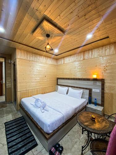 a bedroom with a large bed and a table at Scenic Village Stay near Kufri With Bonfire & Veg Meals-Alpine Crest Homestay Kufri in Theog