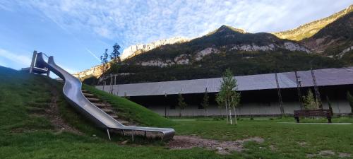 a slide in front of a building with a mountain at Carlina Canfranc in Canfranc-Estación