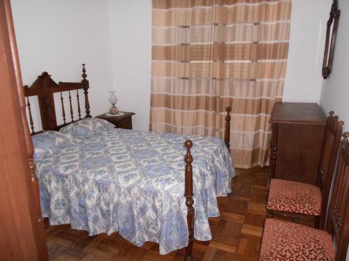 a bedroom with a bed and two chairs and a window at Santo Tirso Holidays Home in Santo Tirso