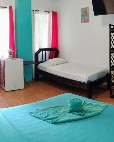a room with two beds in a room at Cool Vibes Beach Hostel in Dominical