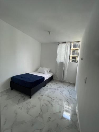a white room with a bed and a window at apto fontana campestre 3 habitaciones con parqueadero in Ibagué