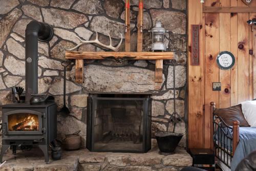a stone fireplace in a room with a stove at River Access Loft Deck WiFI & Pet Friendly in Great Cacapon