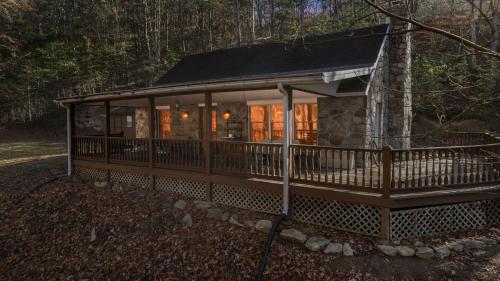 a cabin in the woods with a wrap around porch at River Access Loft Deck WiFI & Pet Friendly in Great Cacapon