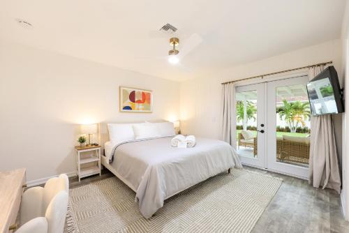 a white bedroom with a bed and a sliding glass door at Casa Bella Naples Vacation Home in Naples