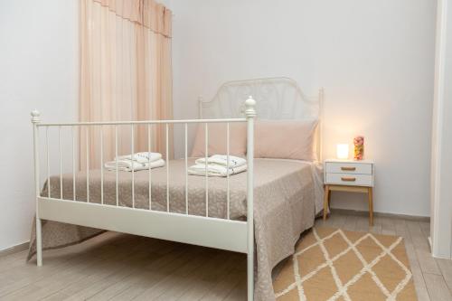 1 dormitorio con 1 cama con marco blanco en A V G E R I N O S Naxos, en Naxos Chora