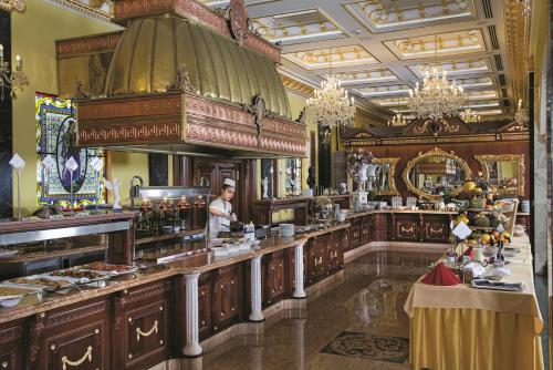 Un homme debout derrière un comptoir dans un restaurant dans l'établissement Aphrodite Palace, à Rajecké Teplice