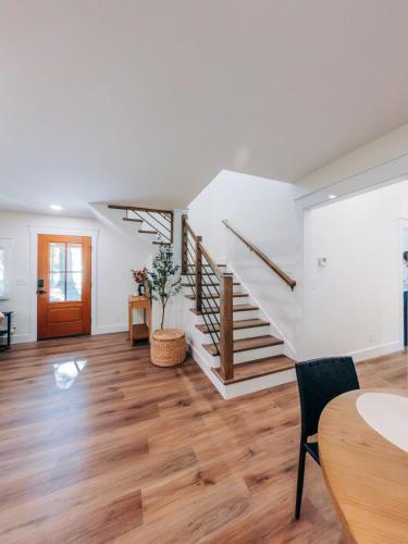 an empty living room with stairs and a table at Little River Retreat in Townsend