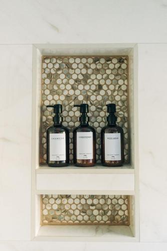 four bottles of soap on a shelf in a bathroom at Little River Retreat in Townsend