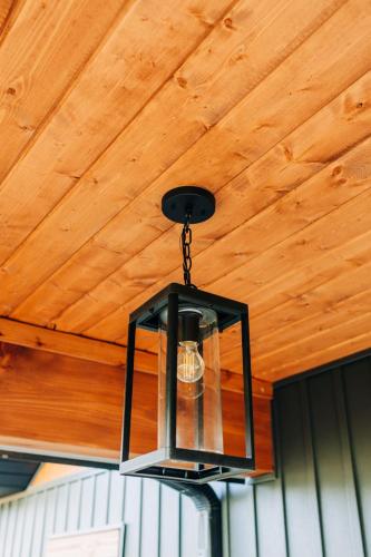 a black chandelier hanging from a wooden ceiling at Little River Retreat in Townsend