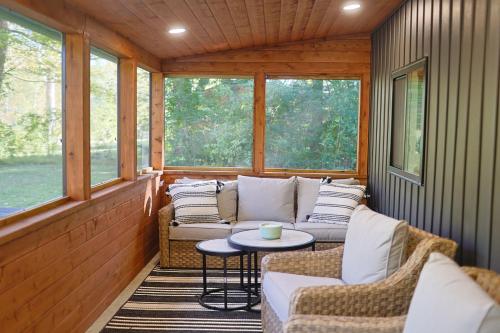 a screened in porch with couches and a table at Little River Retreat in Townsend