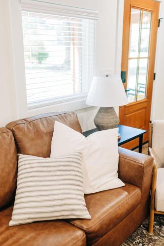 a brown leather couch with pillows on it with a lamp at Little River Retreat in Townsend