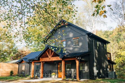 a black house with a gambrel roof at Little River Retreat in Townsend