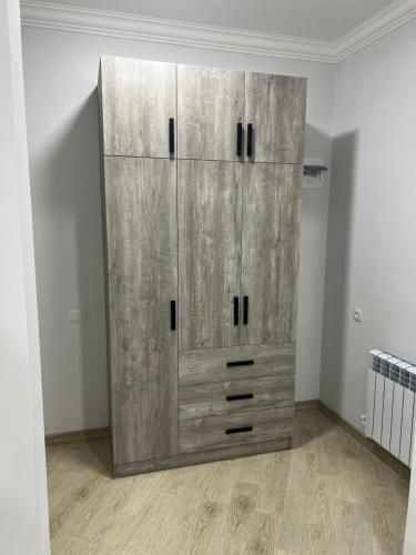 a large wooden cabinet in a room at Home rent in Masis