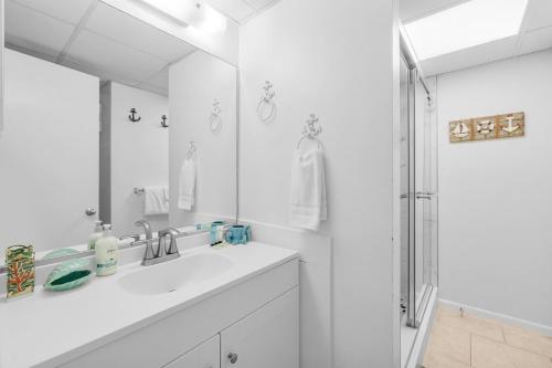 a white bathroom with a sink and a shower at 1st Floor Resort Condo! No Elevators! Free Beach Chair Service! by Dolce Vita Getaways PCB in Panama City Beach