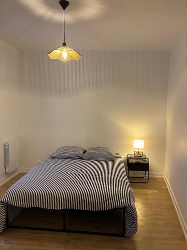 une chambre avec un lit et une lumière sur le mur dans l'établissement Appart 3 pièces très lumineux, à Meudon