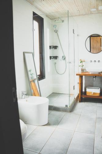 a bathroom with a tub and a shower and a sink at Casa Alma - Lujo y descanso con vista al mar in Pichilemu