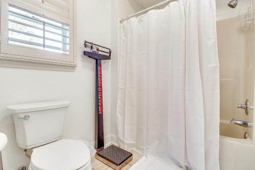 a bathroom with a toilet and a shower curtain at Pool, Dock and Tennis Court Home in Bay St Louis! in Shoreline Park