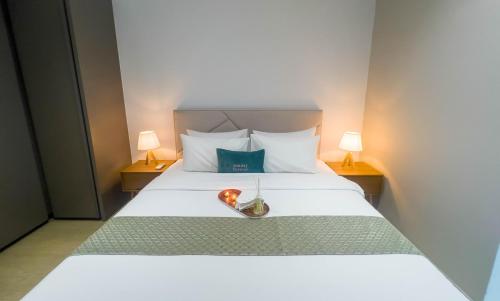 a bedroom with a white bed with two lamps at Eaton Residence KLCC - KL SUITE in Kuala Lumpur