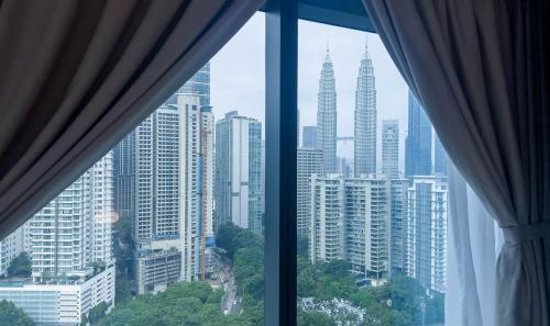 a view of a city skyline from a window at Eaton Residence KLCC - KL SUITE in Kuala Lumpur