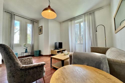 un salon avec un canapé, des chaises et une table dans l'établissement Les Accacias- Appartement confortable en Centre ville, à Annecy