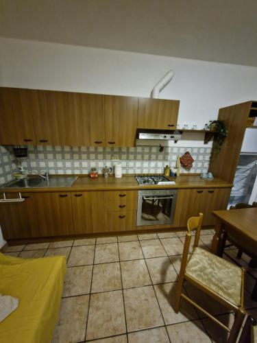 a kitchen with wooden cabinets and a table and a tableablish at Alloggio Ursula in Lagaro