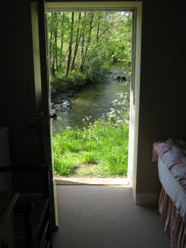 a door leading into a room with a view of a river at Riverside House in Thornhill