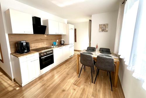 a kitchen with a table and chairs in a room at Apartments Sunnseitn by Gerrit & Herfried in Krumpendorf am Wörthersee
