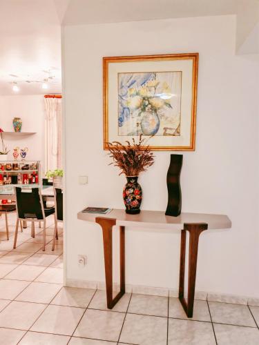 un vase sur une table avec une photo sur le mur dans l'établissement 玫瑰花苑, à Bussy-Saint-Georges